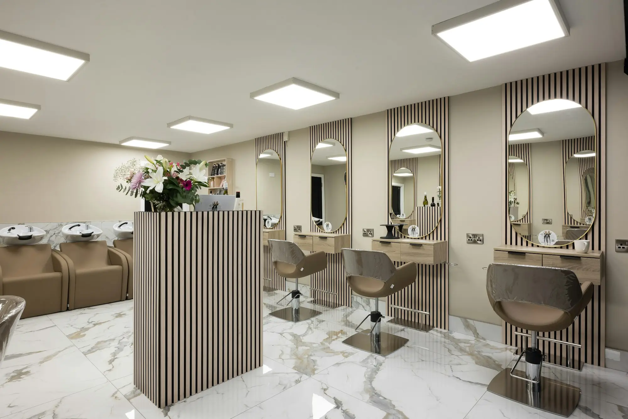 Peluquería y estética en Santa Isabel, Zaragoza | Christian Peluqueros Interior luminoso de una peluquería con sillones, espejos y buena iluminación: peluquería y estética en Santa Isabel, Zaragoza