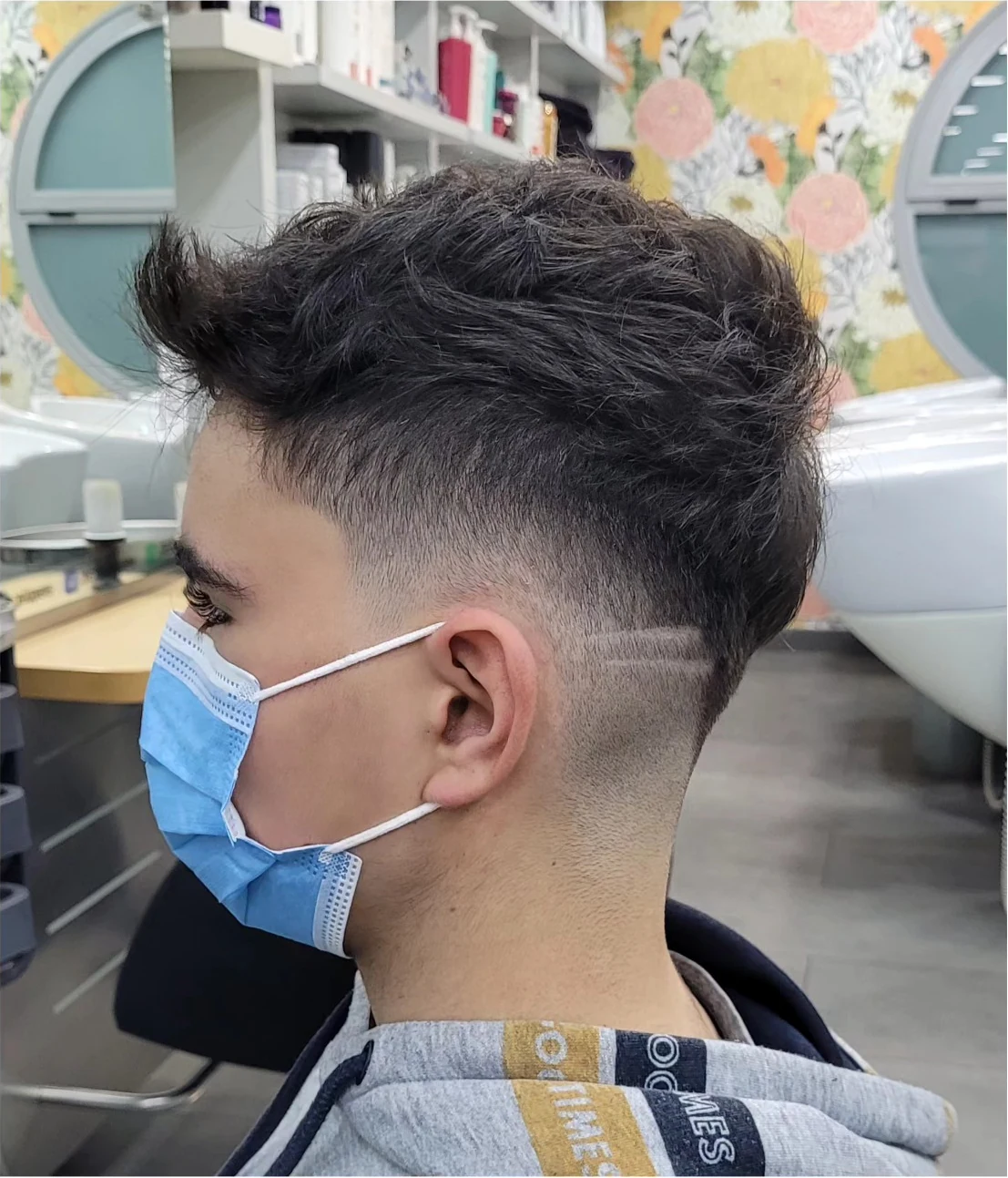 Degradado alto con línea lateral y textura arriba en un corte joven: peluquería para hombre en el barrio de Santa Isabel, Zaragoza